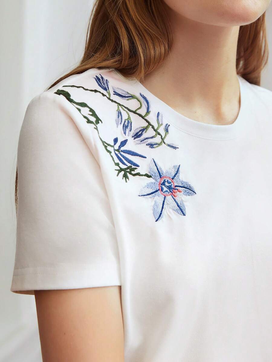 Blusa branca feminina com bordado floral no ombro e manga curta