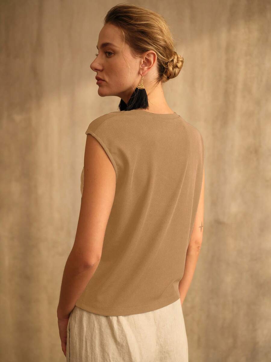 Blusa feminina beige de comprimento regular com decote assimétrico e detalhe metálico decorativo no ombro