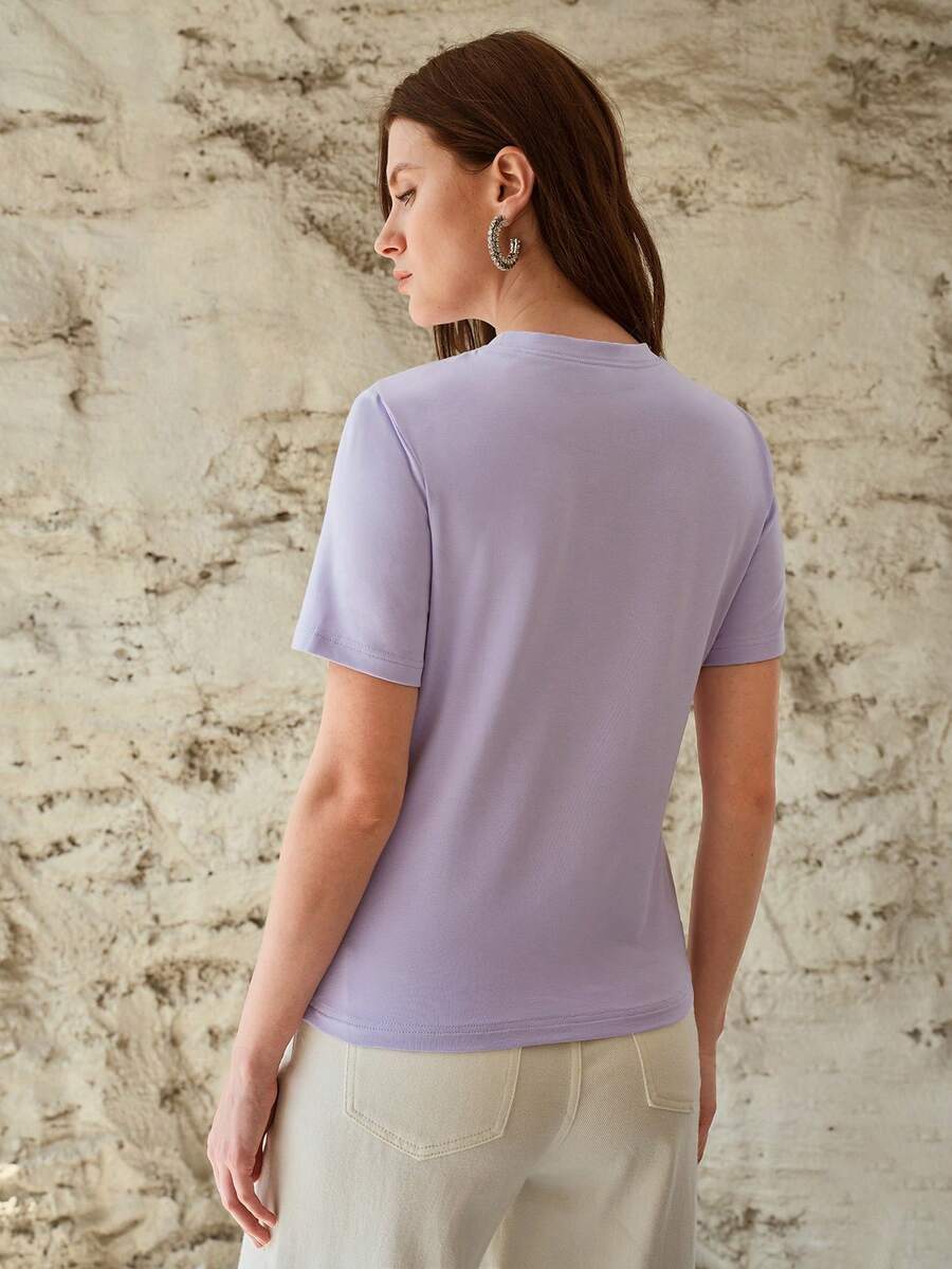Blusa feminina lilás com bordado floral assimétrico e gola redonda
