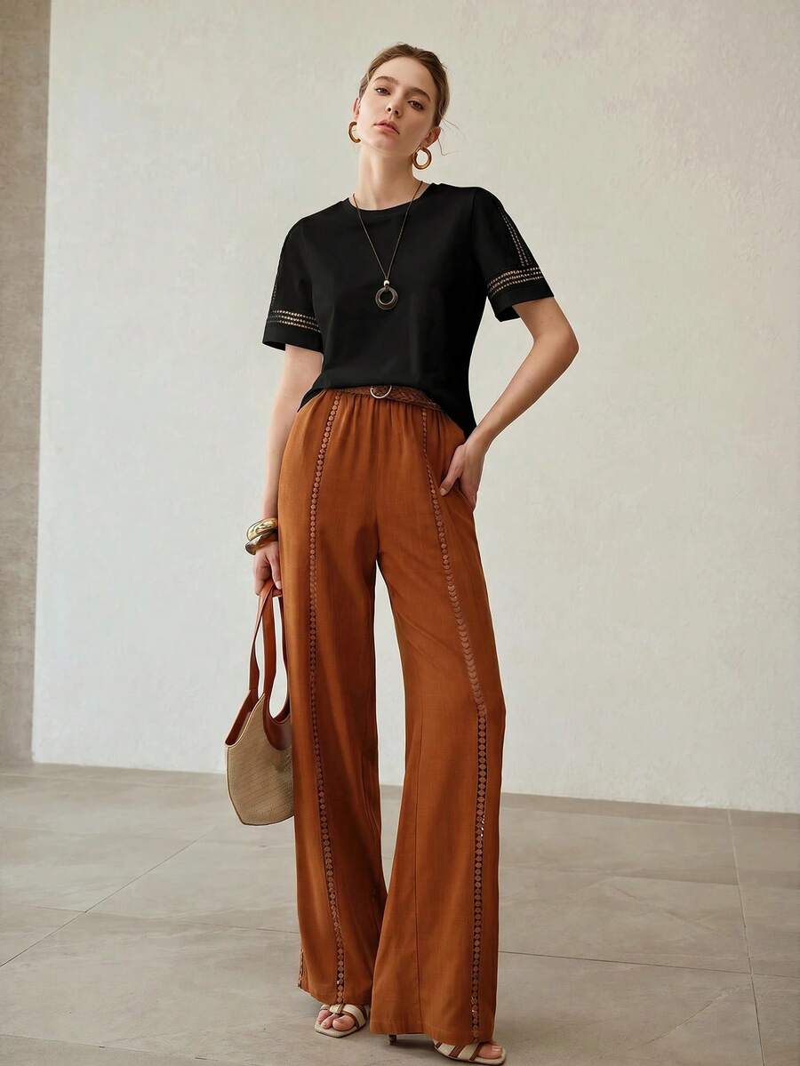 Blusa feminina preta de manga curta com aplicação vazada delicada nos ombros e acabamento elegante