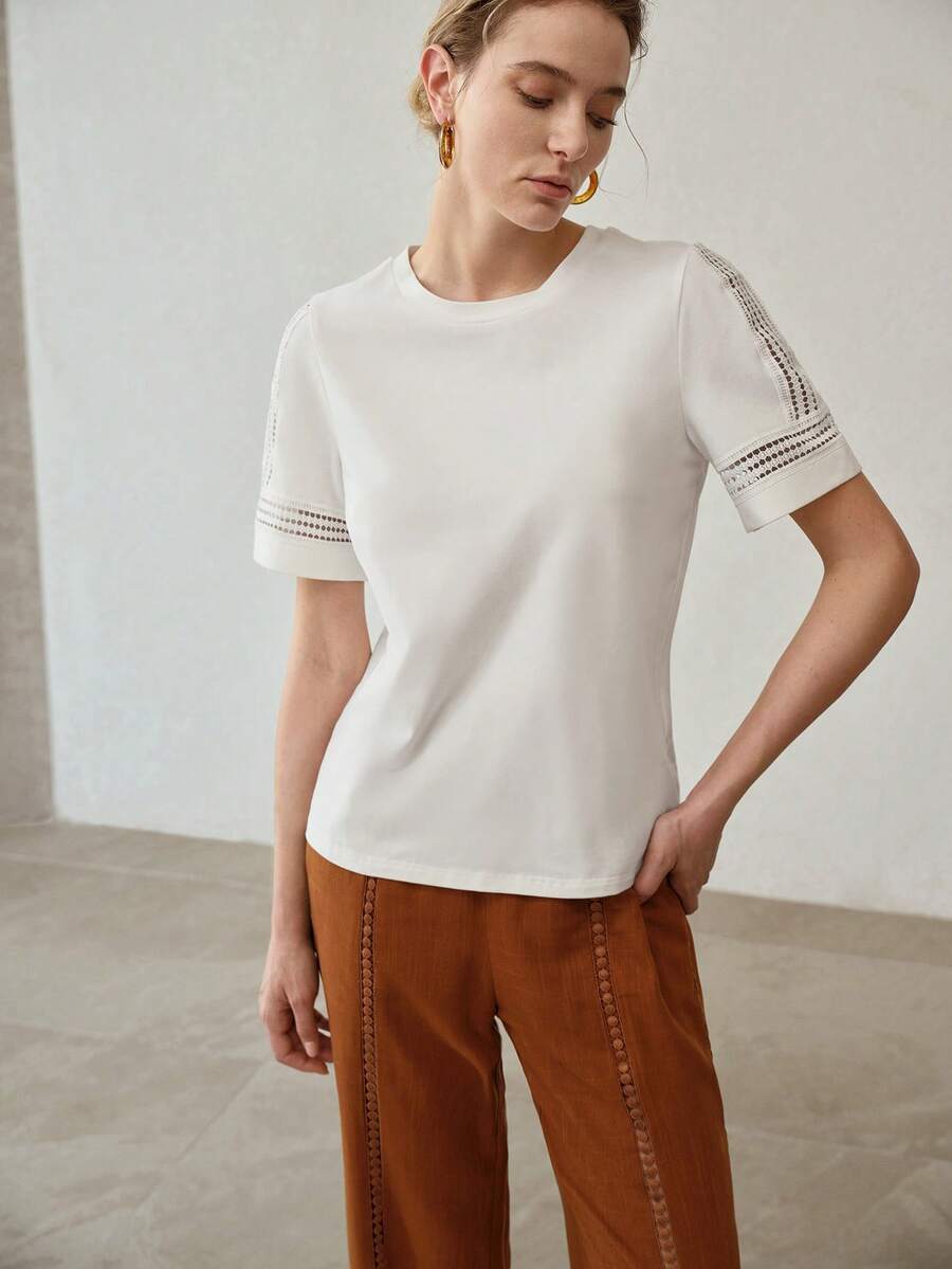 Detalhe da manga curta com aplicação vazada ogeométrica e acabamento decorativo tom sobre tom offwhite