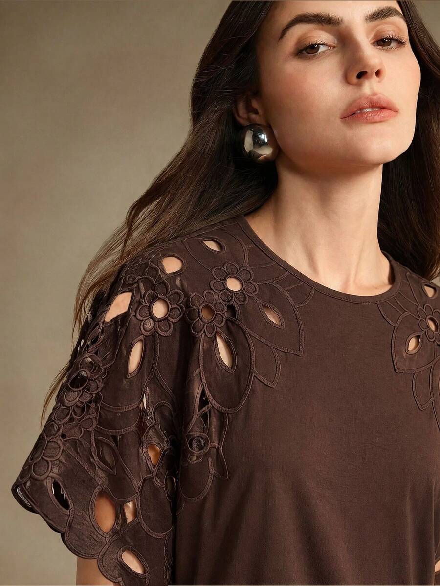 Detalhe dos recortes vazados no ombro e manga curta da blusa feminina cor castanho