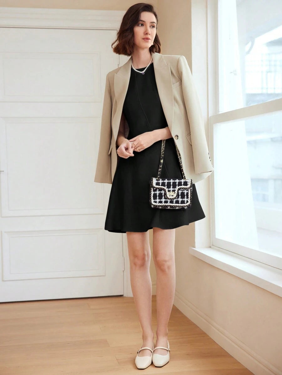 Vestido preto acinturado com saia levemente aberta e design minimalista