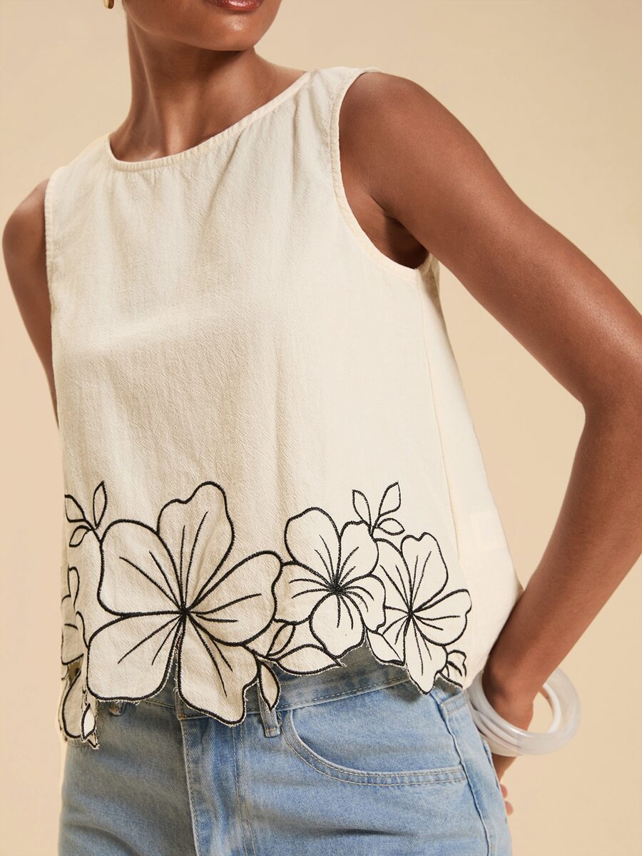 Blusa feminina branca bordada sem mangas com detalhes florais e acabamento delicado