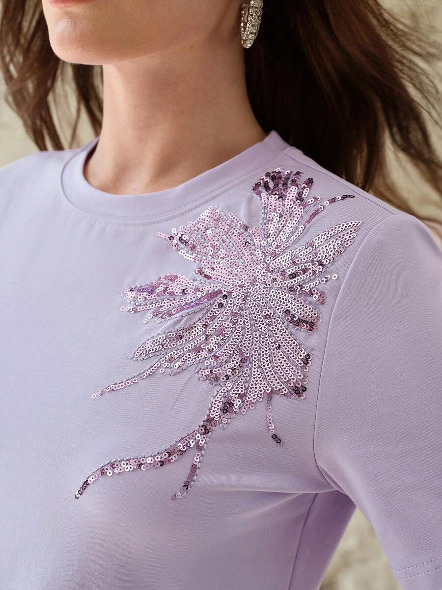 Blusa feminina lilás com bordado floral assimétrico e gola redonda
