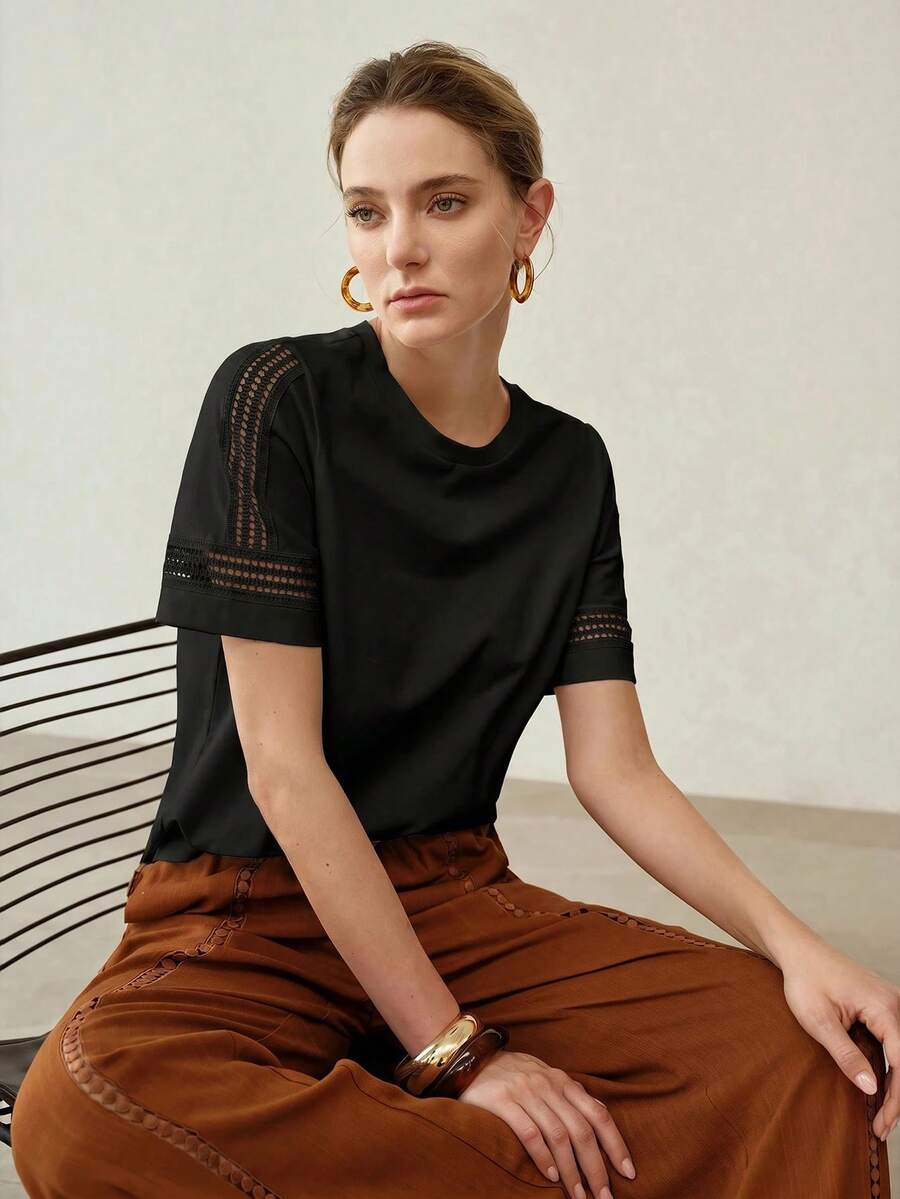Blusa feminina preta com gola redonda e detalhes vazados nas mangas combinada em look casual sofisticado