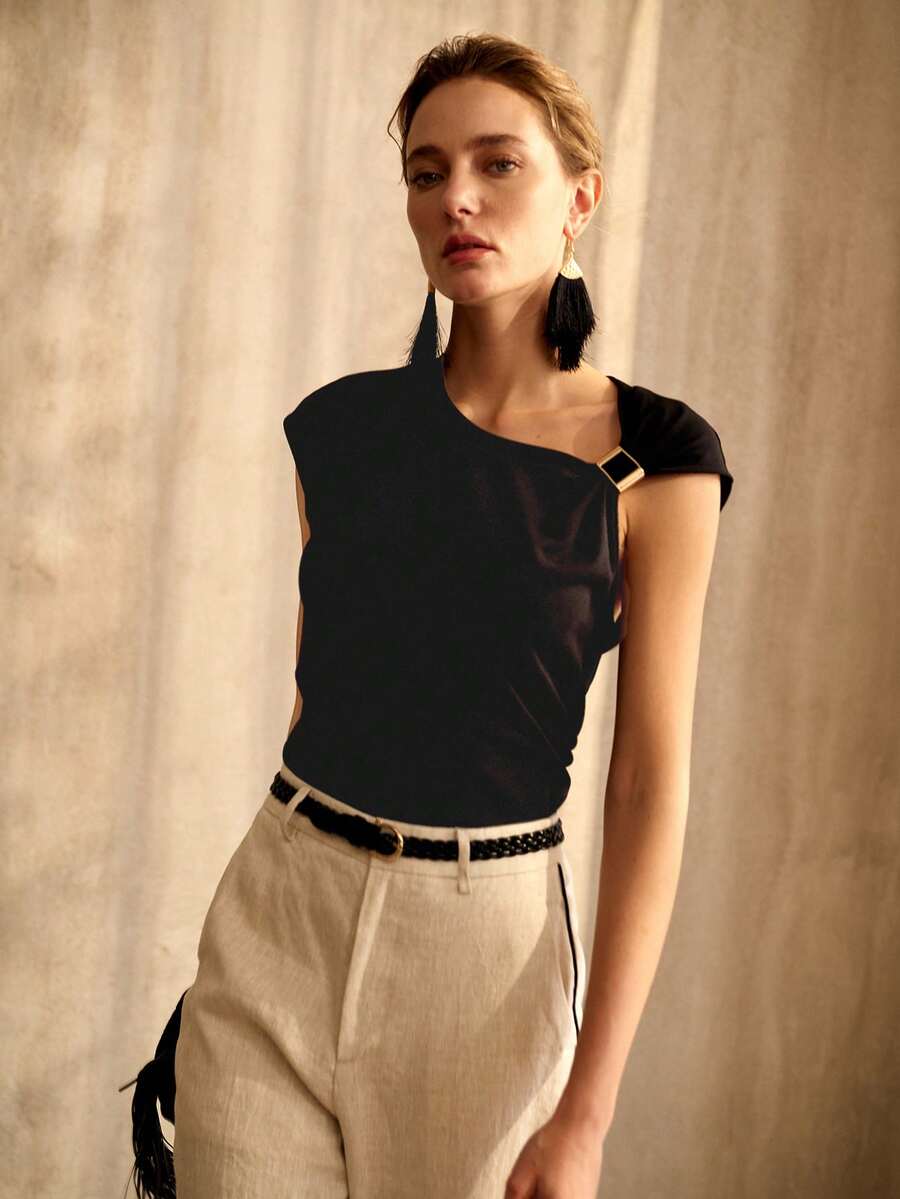 Blusa feminina preta elegante com decote assimétrico, manga boné e detalhe de fivela metálica no ombro