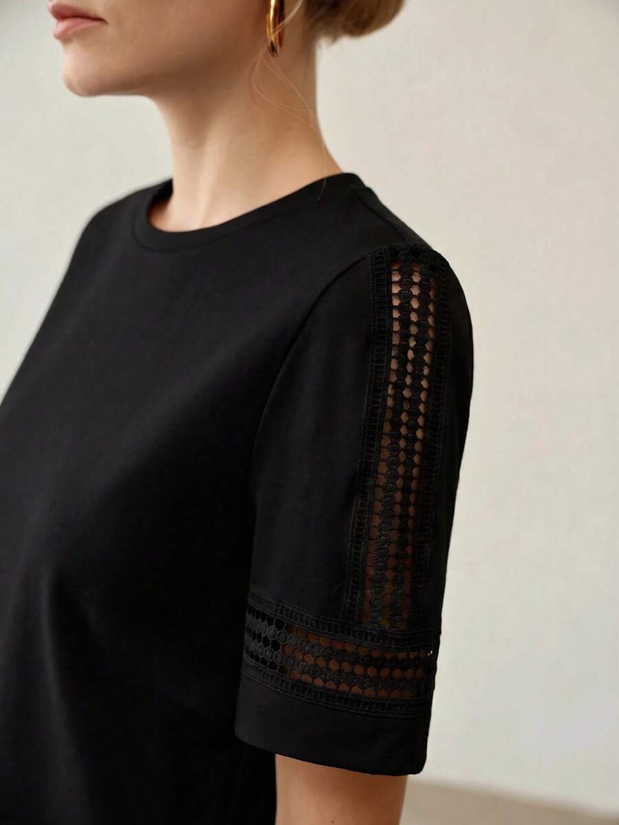 Blusa feminina preta  em malha de algodão com gola redonda, manga curta e detalhes vazados decorativos - Boutique do Encanto 