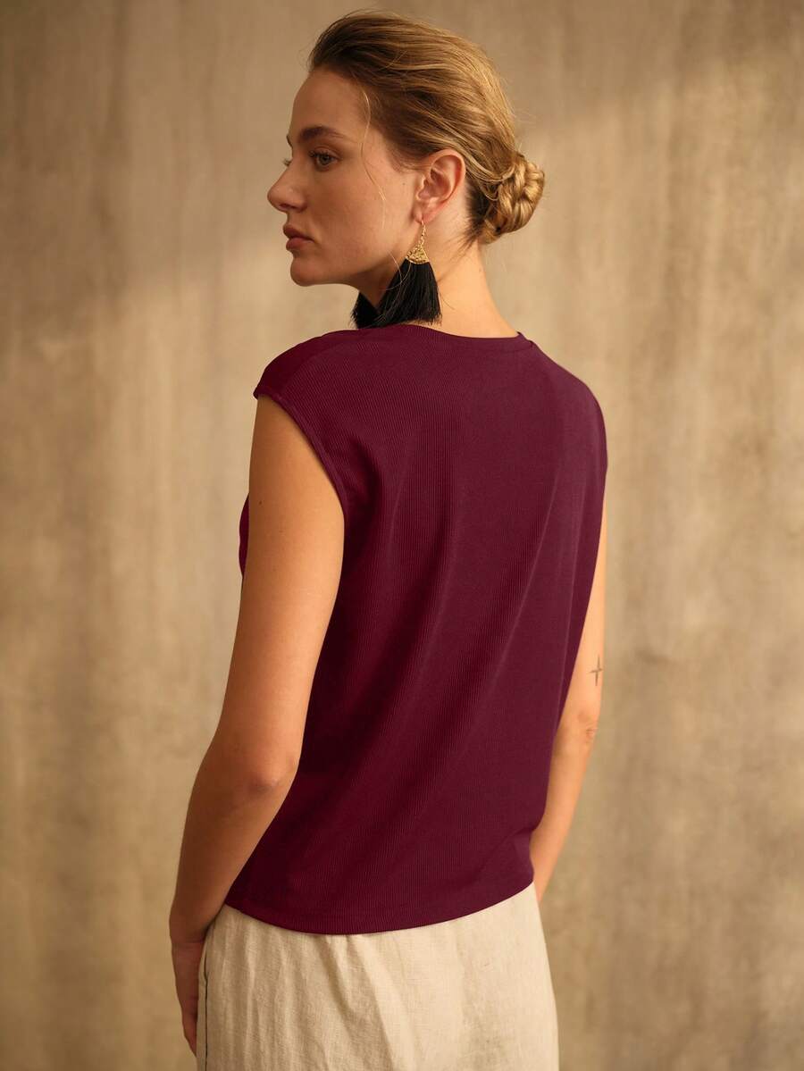 Blusa feminina  vinho com design assimétrico e detalhe metálico no ombro em look casual refinado