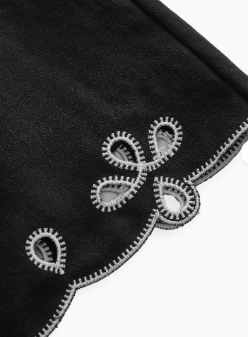 Bordado da barra: Detalhe da barra recortada com bordado vazado contrastante do vestido mini feminino preto
