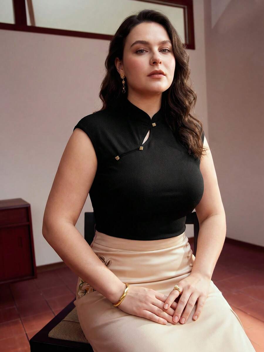 Detalhe da malha canelada preta e aplique metálico dourado com acabamento delicado no decote Plus Size 