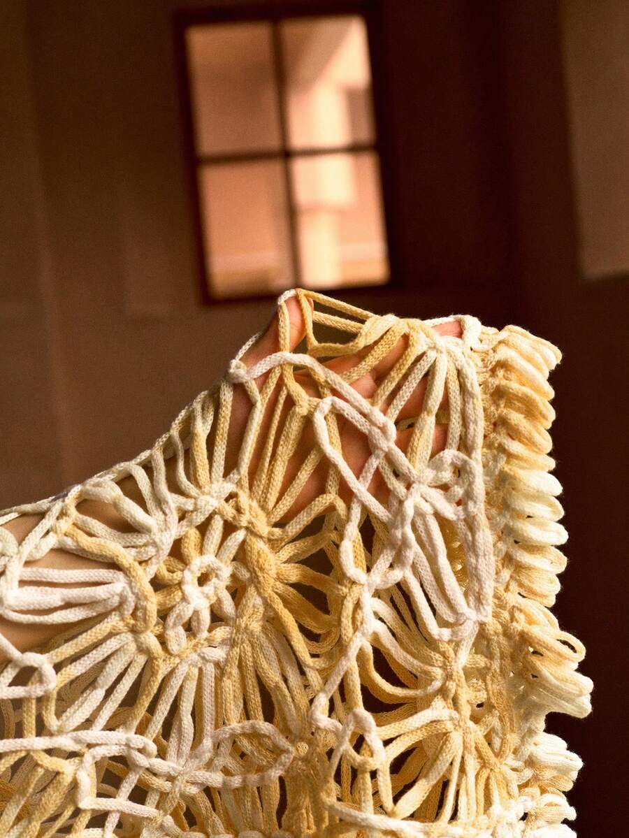 Detalhe da saída de praia em tricô vazado floral amarelo manteiga