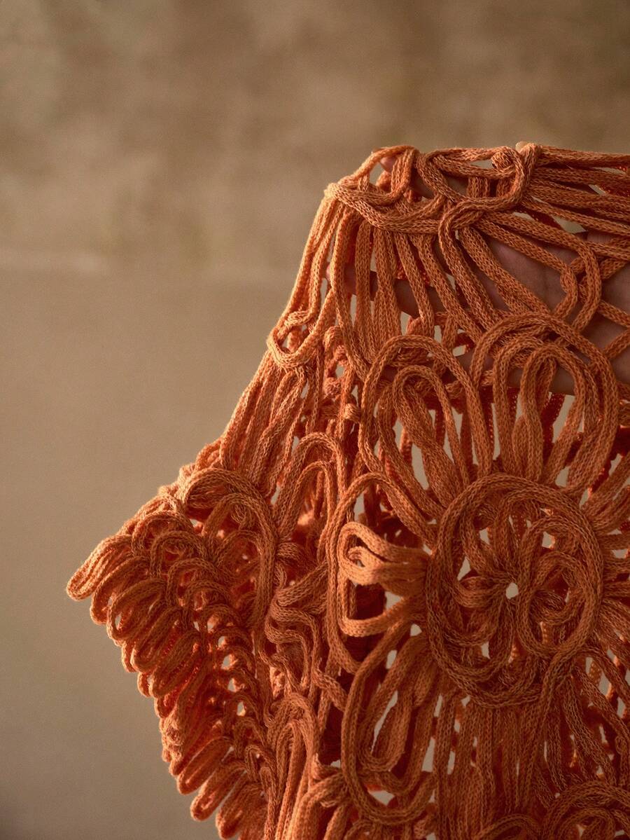 Detalhe da saída de praia feminina em tricô floral cor tijolo