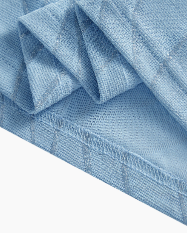 Detalhe da trama da blusa Plus Size Azul Claro com fibras metalizadas e acabamento da bainha