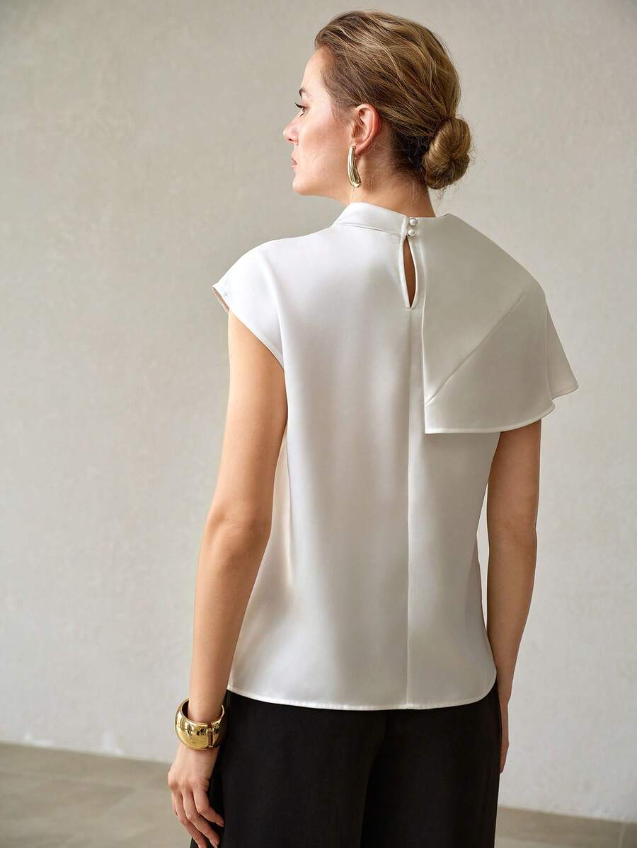 Detalhe do fechamento com botões perolados da blusa feminina