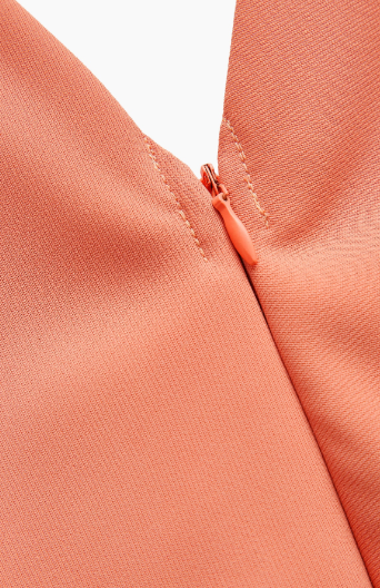 Detalhe do zíper discreto do vestido Rosa Coral Suave, com acabamento e costuras no mesmo tom do tecido.