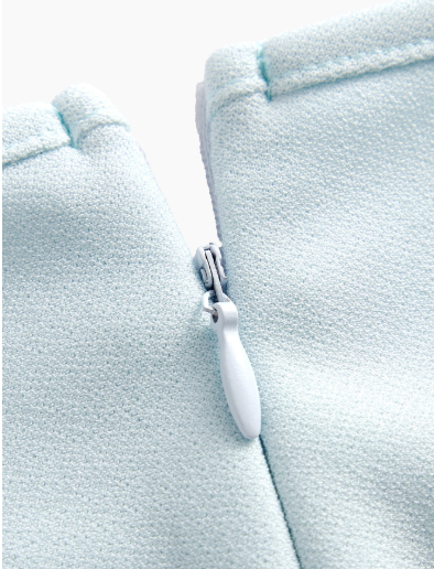 Detalhe do zíper traseiro discreto do vestido feminino azul claro