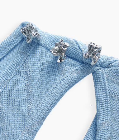 Detalhe dos adornos metálicos e recorte vazado da blusa Plus Size Azul Claro