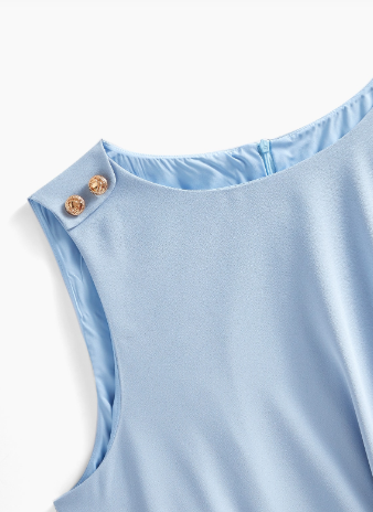 Detalhe dos botões dourados no ombro do vestido Plus Size