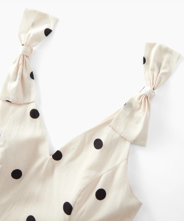Detalhe dos laços estruturados nos ombros do vestido Creme & Preto com estampa de poá.