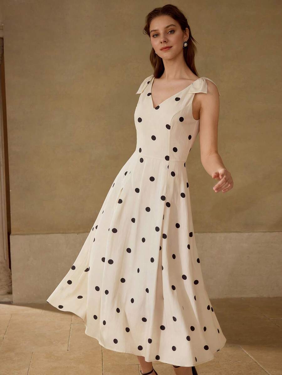 Vestido Creme & Preto com decote V e laços decorativos nos ombros.