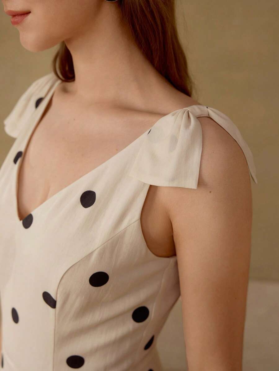 Vestido feminino de poá com decote V, cintura alta e saia ampla.