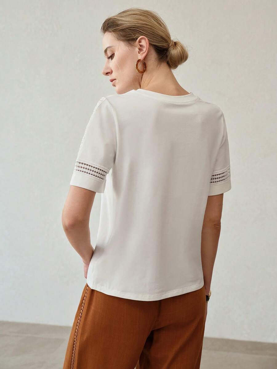Vista frontal da blusa feminina off white  em algodão com modelagem regular e detalhes vazados nas mangas