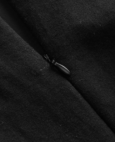 Zíper: Detalhe do zíper invisível posterior do vestido mini preto feminino com acabamento discreto
